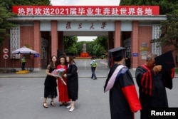 资料照：上海复旦大学学生在校门拍摄毕业照。（2021年6月25日）