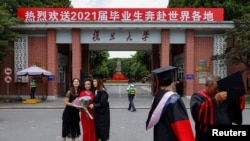 上海復旦大學學生在校門拍攝畢業照。（2021年6月25日）