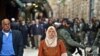Una mujer musulmana camina por la ciudad Vieja de Jerusalén, fuertemente custodiada por policías israelíes durante el primer viernes del mes sagrado del Ramadán.