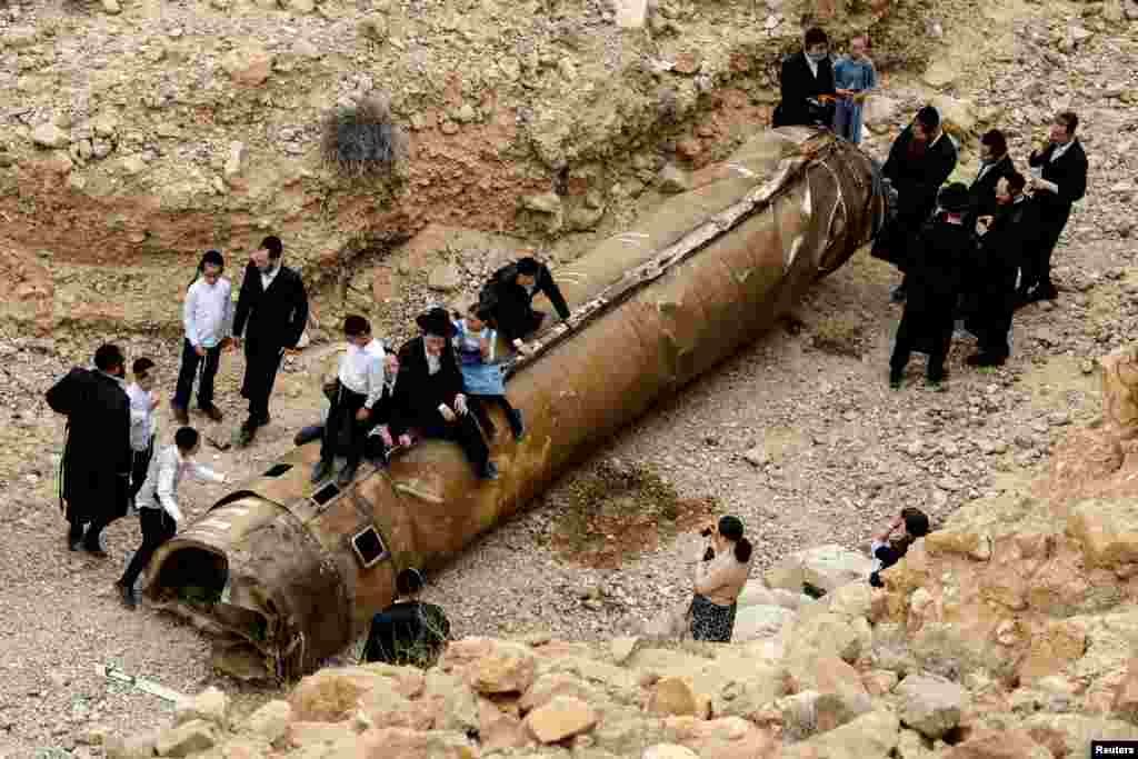 Ultra Orthodox Jews hang around apparent remains of a ballistic missile found lying in the desert, following a massive missile and drone attack by Iran on Israel, near the southern city of Arad, Israel.