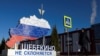 FILE - A woman walks past an installation that displays the map of the Belgorod region and the slogan “Shebekino does not bow down,” in the town of Shebekino, Russia, March 11, 2024.