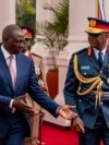 FILE - Chief of Kenya Defense Forces General Francis Ogolla (R) speaks to Kenyan President William Ruto as they prepare to receive Britain's King Charles III and Queen Camilla during the ceremonial welcome at the State House in Nairobi on Oct. 31, 2023.