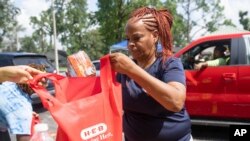 Debra McCarty with Harris County Precinct 1 works to distribute food at Lincoln Park in Houston, on July 10, 2024.