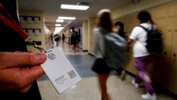 Salah satu petugas sekolah di SMA Olathe South di Olathe, Kansas, menunjukkan tombol peringatan bahaya yang diberlakukan dii sekolah tersebut pada 19 Agustus 2022. (Foto: AP/Charlie Riedel)