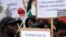 FILE: Migrants associations members show banners reading in Italian "All brothers, we want peace because we know war, residence permit" during a protest against Italy's government's migrants' policy in Rome, Tues. April 18, 2023.