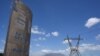 FILE - A dilapidated sign for Eskom, the South African electricity authority, stands next to electricity pylons and Table Mountain in the distance near Cape Town on January 22, 2023