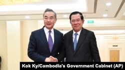 រូបឯកសារ៖ លោក​នាយករដ្ឋមន្ត្រី​ ហ៊ុន សែន (ស្តាំ) ចាប់​ដៃ​ជាមួយ​រដ្ឋមន្ត្រី​ការ​បរទេស​ចិន​លោក Wang Yi (វ៉ាង យី) នៅ​វិមាន​សន្តិភាព ក្នុង​រាជធានី​ភ្នំពេញ កាល​ពី​ថ្ងៃ​អាទិត្យ ទី​១៣ ខែ​សីហា ឆ្នាំ​២០២៣។ (Kok Ky/Cambodia's Government Cabinet via AP)