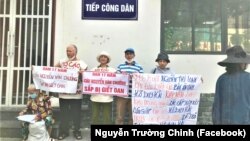 Ông Nguyễn Trường Chinh (trái) cùng mẹ của tử tù Hồ Duy Hải (phải) và những người ủng hộ căng băng rôn trước cơ quan công quyền ở Hà Nội để kêu oan cho con trai ông, Nguyễn Văn Chưởng, người bị kết án tử hình năm 2007.