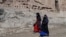 FILE - Afghan women walk near the site of the Buddhas of Bamiyan statues, which were destroyed by the Taliban in 2001, in Bamiyan province, Afghanistan, March 7, 2024. Bamiyan is the site of a gun attack on Western tourists on May 17, 2024.