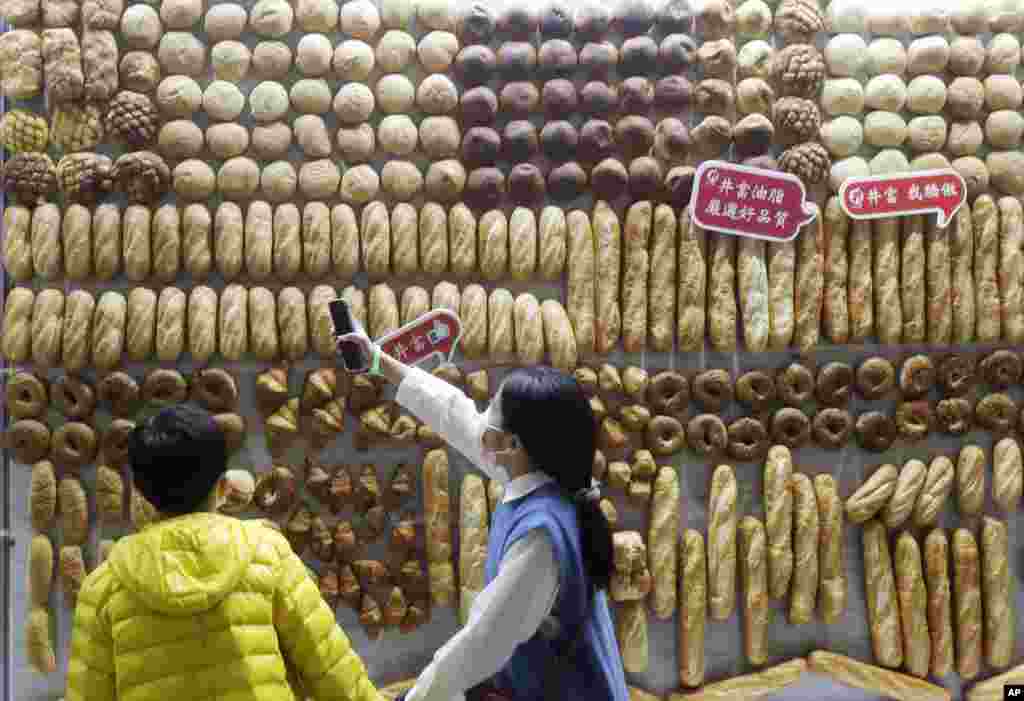 Children look at a wall of bread on display during the Bakery Show at Taipei Nangang Exhibition Center in Taipei, Taiwan.