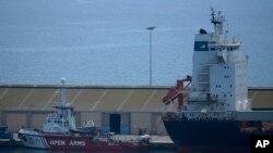 Vista del barco Open Arms y del portacontenedores Sagamore, derecha, atracados en el puerto de Larnaca, Chipre, el miércoles 8 de mayo de 2024, donde se cargan alimentos con destino a Gaza para su eventual entrega. (Foto AP/Petros Karadjias)