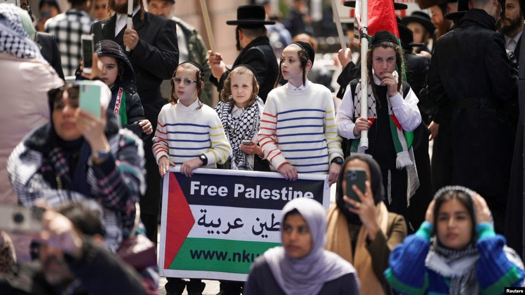 Ortodoksni Jevreji drže plakat koji pokazuje solidarnost s Palestincima dok se okupljaju ispred kampusa Univerziteta Columbia 26. aprila 2024.