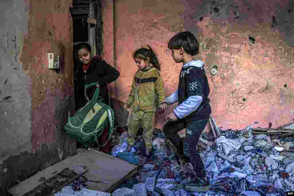 Children inspect items in the rubble in a room destroyed by Israeli bombardment in Rafah in the southern Gaza Strip amid the ongoing conflict between Israel and the militant group Hamas.