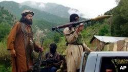 FILE - Members of the Pakistani Taliban, known as the TTP, patrol in Shawal, in the Pakistani tribal region of South Waziristan, Aug. 5, 2012.