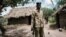 FI:LE: Kenyan police officers stand outside the abandoned dwelling of followers of the the Good News International Church, believed to be practising mass starvation, in Shakahola, outside the coastal town of Malindi, on April 25, 2023. 
