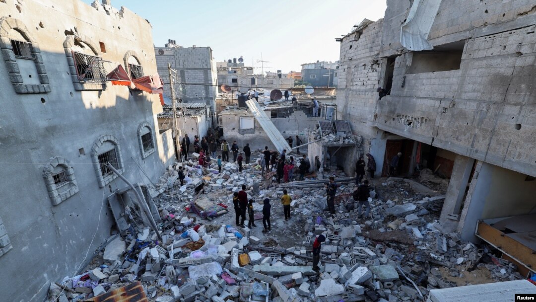 Palestinos inspeccionan los escombros dejados por misil israelí que impactó contra viviendas en Rafah, en la franja de Gaza, el 29 de diciembre, en la ofensiva de Israel contra Hamás.