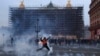 A protester kicks a tear gas canister in front of the Opera at the end of a rally in Paris, March 23, 2023.
