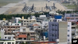 FILE - MV-22 Ospreys are seen at the U.S. Marine Corps Futenma Air Station and the surrounding area from an observation deck at a park in Ginowan, Okinawa Prefecture, Japan, March 23, 2015.