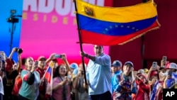 President Nicolas Maduro waves a Venezuelan flag during his closing election campaign rally in Caracas, Venezuela, July 25, 2024.