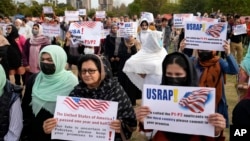 Afghan refugees hold placards during a rally protesting U.S. visa processing delays, in Islamabad, Pakistan, Feb. 26, 2023.