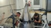 Senior Airman Jacob Deas, 23, left, and Airman 1st Class Jonathan Marrs, 21, right, secure the titanium shroud at the top of a Minuteman III intercontinental ballistic missile on Aug. 24, 2023, at the Bravo 9 silo at Malmstrom Air Force Base in Montana. (U.S. Air Force)
