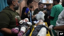 Palestinian children wounded in the Israeli bombardment of the Gaza Strip are brought to the hospital in Deir al Balah, Gaza Strip, Dec. 11, 2023. 