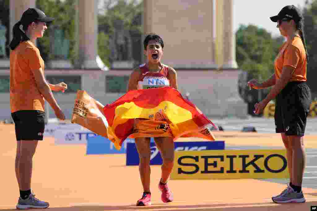 Maria Perez of Spain celebrates as she crosses the finish line to win the Women's 35-kilometer race walk during the World Athletics Championships in Budapest, Hungary.