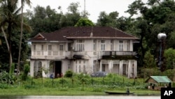 FILE - Seorang pria mendayung melewati rumah pemimpin pro-demokrasi Myanmar Aung San Suu Kyi di tepi danau di Yangon, Myanmar, 11 Agustus 2009. (AP/Khin Maung Win)