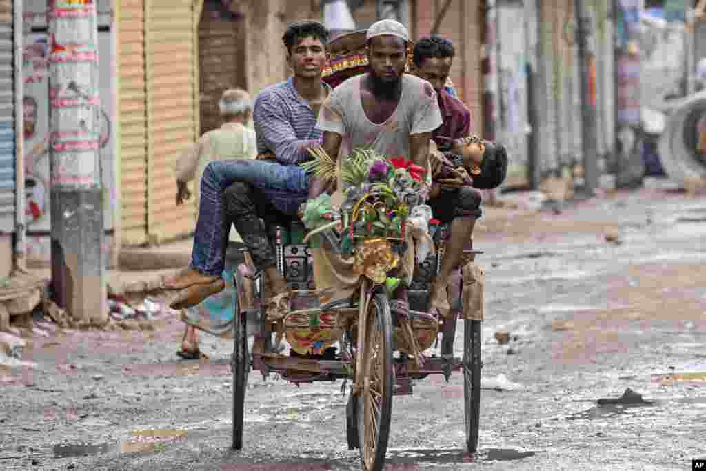 Orang-orang membawa seorang pengunjuk rasa yang terluka dengan becak ke rumah sakit setelah ia ditembak oleh polisi selama aksi protes menentang PM Sheikh Hasina dan pemerintahannya, di Dhaka, Bangladesh. (AP)&nbsp;