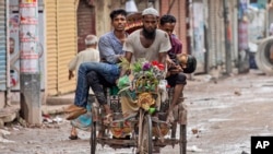 FILE - People carry an injured protester in a cycle rickshaw to a hospital after he was shot at by the police during a protest against Prime Minister Sheikh Hasina and her government, in Dhaka, Bangladesh, Aug. 5, 2024.