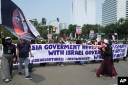 Aksi unjuk rasa di Jakarta, Senin, 20 Maret 2023, memprotes partisipasi tim Israel di Piala Dunia FIFA U-20 di Indonesia. (AP/Achmad Ibrahim)