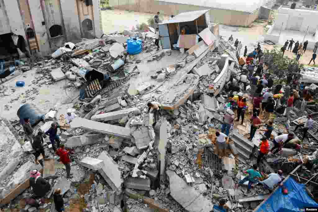 Palestinians search through the rubble of a house destroyed in Israeli strikes in Khan Younis in the southern Gaza Strip, Oct. 8, 2023. 