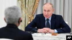 Russian President Vladimir Putin speaks to India's Foreign Minister Subrahmanyam Jaishankar, back to a camera, during their meeting at the Kremlin in Moscow, Dec. 27, 2023.