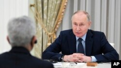 Presiden Rusia Vladimir Putin berbicara dengan Menteri Luar Negeri India Subrahmanyam Jaishankar, menghadap kamera, selama pertemuan mereka di Kremlin di Moskow, 27 Desember 2023. (Foto: via AP)