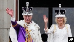 Raja Inggris Charles III dan Ratu Camilla menyapa massa dari balkon Istana Buckingham usai upacara penobatan di London, Sabtu, 6 Mei 2023. (Foto: AP/Frank Augstein)
