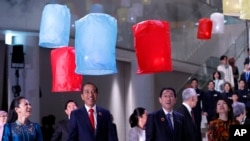Japan's Prime Minister Fumio Kishida, center right, his wife Yuko Kishida, right, Indonesian President Joko Widodo, center left, and other leaders from ASEAN nations and their spouses release paper lanterns at Azabudai Hills in Tokyo, Dec. 17, 2023. 