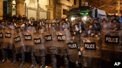 Riot police block a street to stop protesters outside the Georgian parliament building in Tbilisi, Georgia, March 8, 2023. 