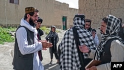 FILE - Taliban-trained suicide bomber Ismail Ashuqullah (L) speaks with Taliban's General Directorate of Intelligence (GDI) after an interview with AFP in Otarhi village in Tangi valley of Saydabad district, Maidan Wardak province, May 25, 2023. 