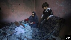 Palestinians salvage their belongings after an Israeli strike in Rafah, Gaza Strip, Dec. 24, 2023.