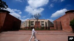 A man walks past the new Parliament building in New Delhi, India, Sept. 18, 2023. Parliament's lower house has passed a bill that sets aside 33% of the seats in the lower house and state assemblies for women.