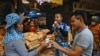 A vendor serves ice cream to flower vendors during a heatwave in Bangkok on April 25, 2023. 