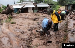 Men dig in search of survivors and victims in the mud and debris left by Cyclone Freddy in Chilobwe, Blantyre, Malawi, March 13, 2023.