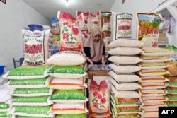 Seorang pedagang menjaga kios berasnya di Jakarta, di tengah kenaikan harga dan kekurangan bahan pokok di Indonesia, 28 Februari 2024. (ADEK BERRY/AFP)