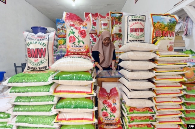 Seorang pedagang menjaga kios berasnya di Jakarta, di tengah kenaikan harga dan kekurangan bahan pokok di Indonesia, 28 Februari 2024. (ADEK BERRY/AFP)