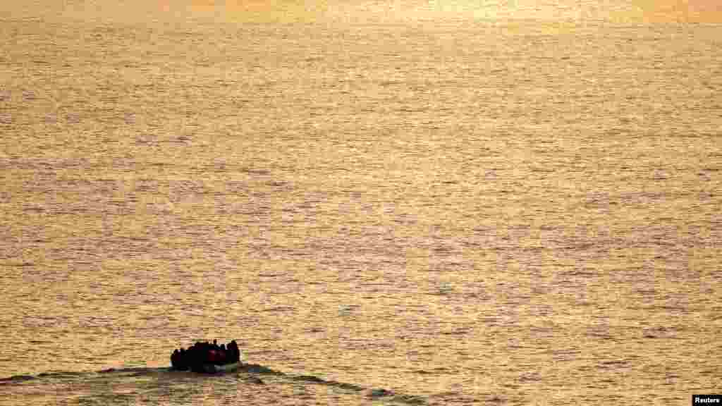 Sekelompok migran yang menaiki perahu karet terlihat saat matahari terbit dari kapal penyelamat Prancis &quot;Abeille Normandie&quot; ketika mereka mencoba menyeberangi Selat Inggris dari pantai utara Prancis. (Reuters)&nbsp;