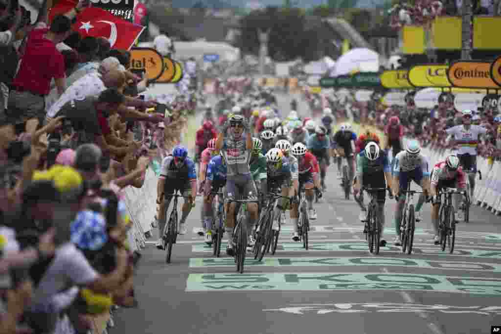 Belgium&#39;s Jasper Philipsen celebrates as he crosses the finish line to win the tenth stage of the Tour de France cycling race over 187.3 kilometers (116.4 miles) with start in Orleans and finish in Saint-Amand-Montrond, France.