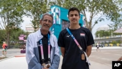 Yemeni swimmer Yusuf Marwan, right, poses for a photo with his coach ahead of his first Olympic competition, during the 2024 Summer Olympics, July 31, 2024, in Paris, France, .