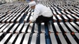 FILE - A worker is pictured with car batteries at a Xinwangda Electric Vehicle Battery Co. plant, which makes lithium batteries for electric cars and other uses, in Nanjing, China, March 12, 2021.