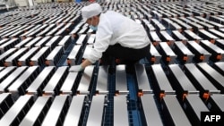 FILE - A worker is pictured with car batteries at a Xinwangda Electric Vehicle Battery Co. plant, which makes lithium batteries for electric cars and other uses, in Nanjing, China, March 12, 2021.