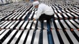 FILE - This photo taken March 12, 2021, shows a worker with car batteries at a factory for Xinwangda Electric Vehicle Battery Co. Ltd., which makes lithium batteries for electric cars and other uses, in Nanjing, Jiangsu province, China. 